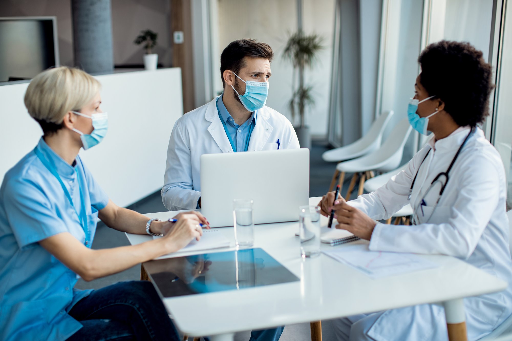 group-healthcare-experts-with-face-masks-talking-meeting-medical-clinic